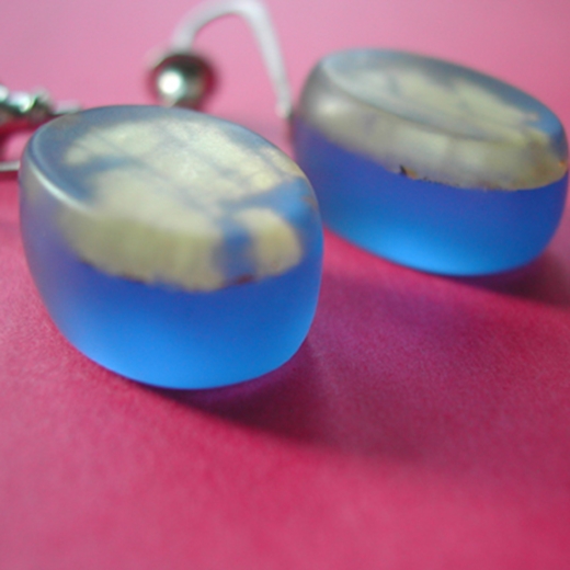 detail of blue oval drop earrings with gold leaf layer