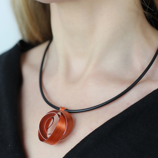 Orange wide ribbon coil pendant worn