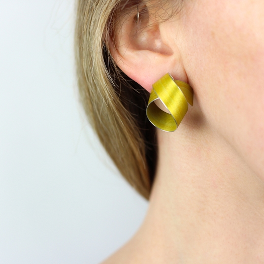 Yellow wide coil stud earrings worn