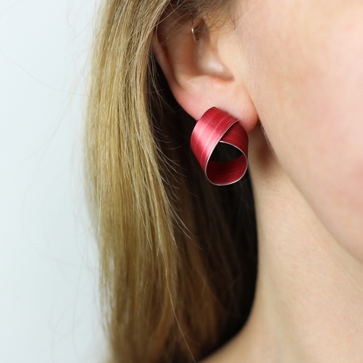 Red wide coil stud earrings worn