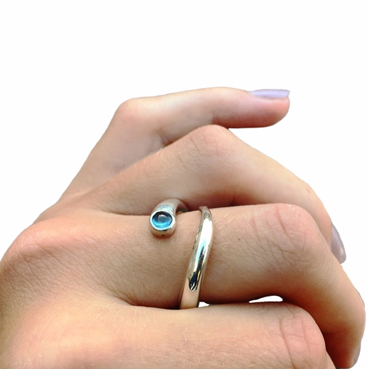 Curving silver ring with blue topaz